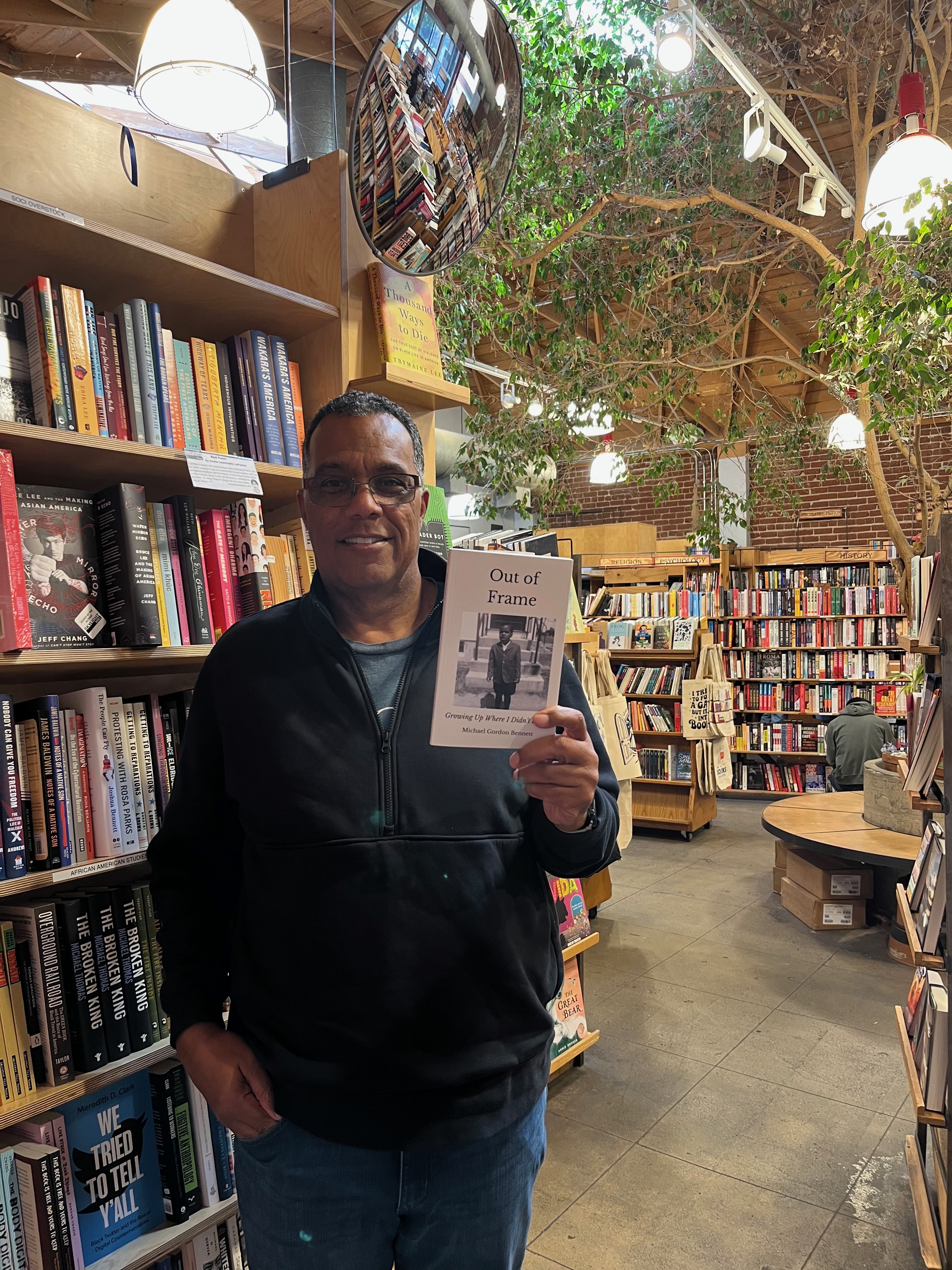 Michael Gordon Bennett holding a copy of Out of Frame